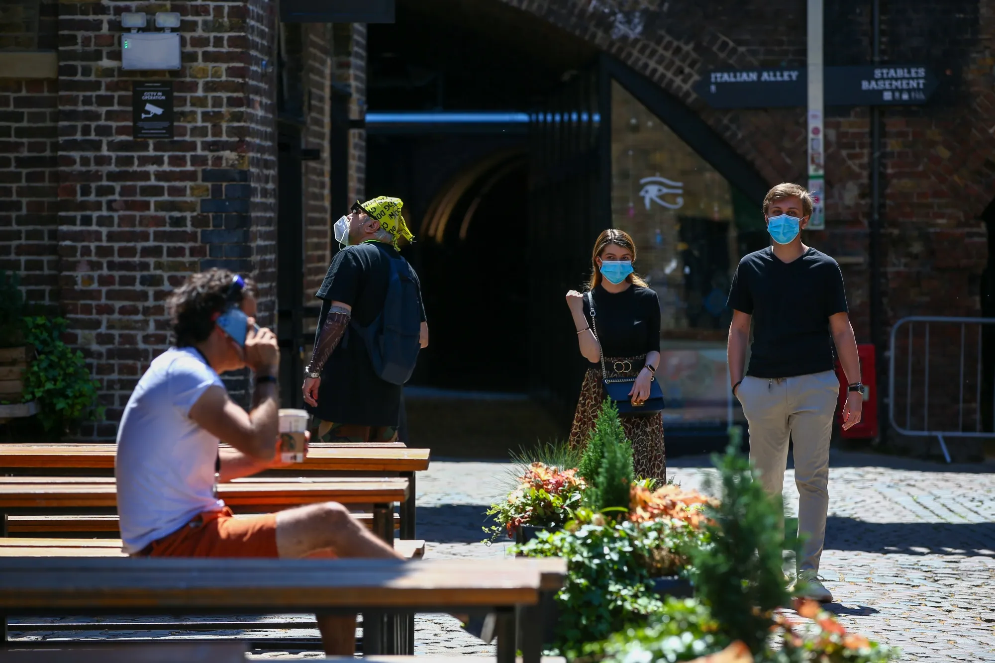 Pedestrians wearing a protective face masks browse stalls at Camden Market, as it re-opens, in London on June 1, 2020.&nbsp;