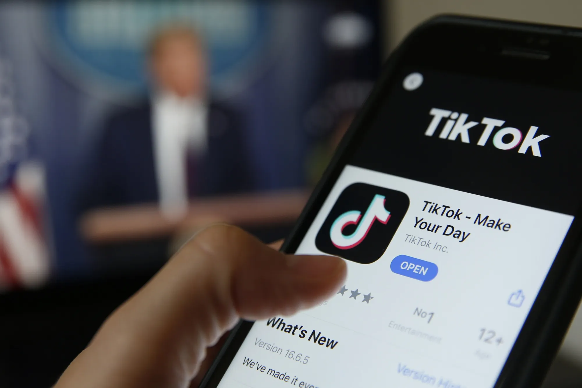 The TikTok app is displayed in the app store in this arranged photograph in view of a video feed of U.S. President Donald Trump in London, U.K., on Monday, Aug. 3, 2020.&nbsp;