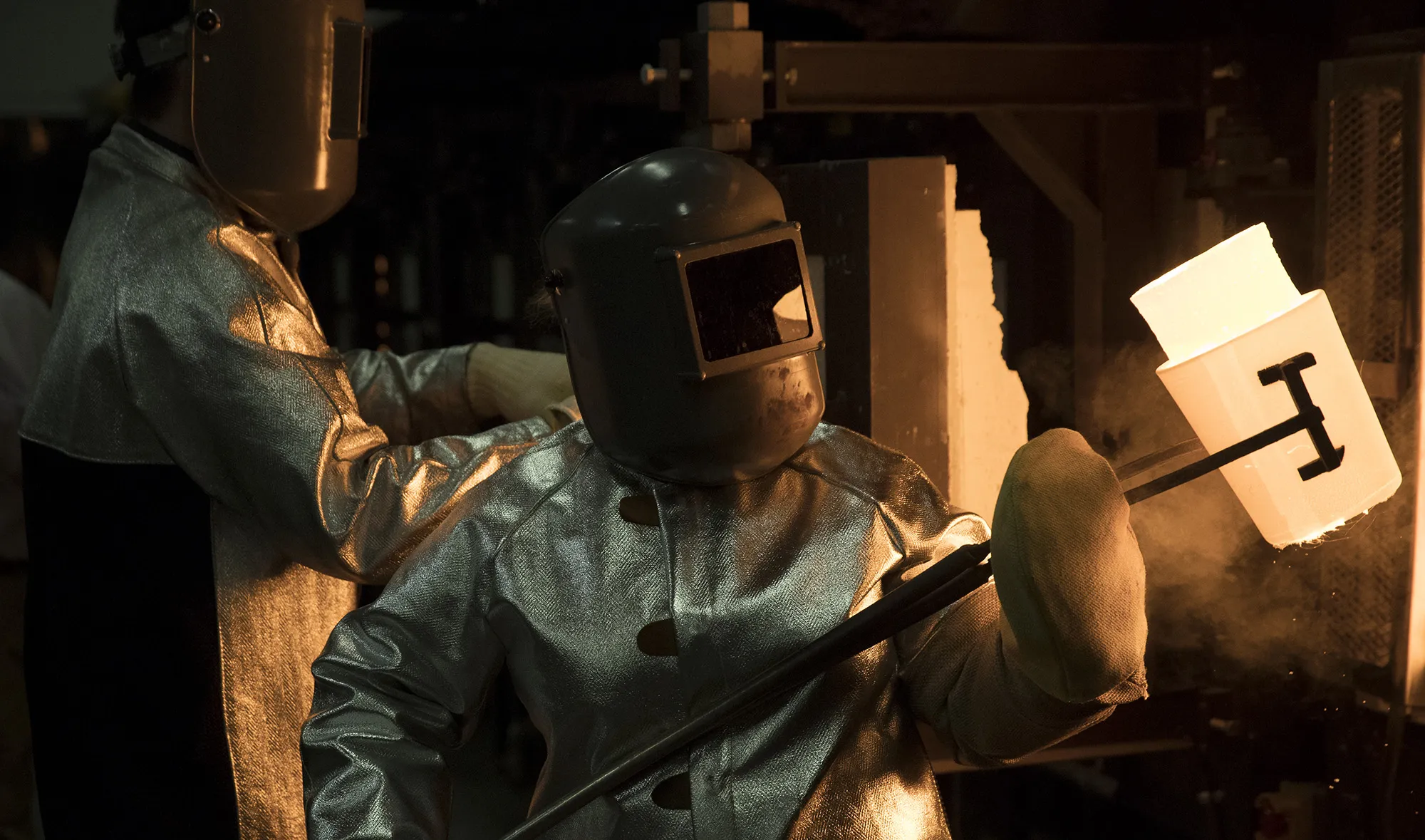 A worker pulls a crucible of molten glass from a furnace in Corning, New York.