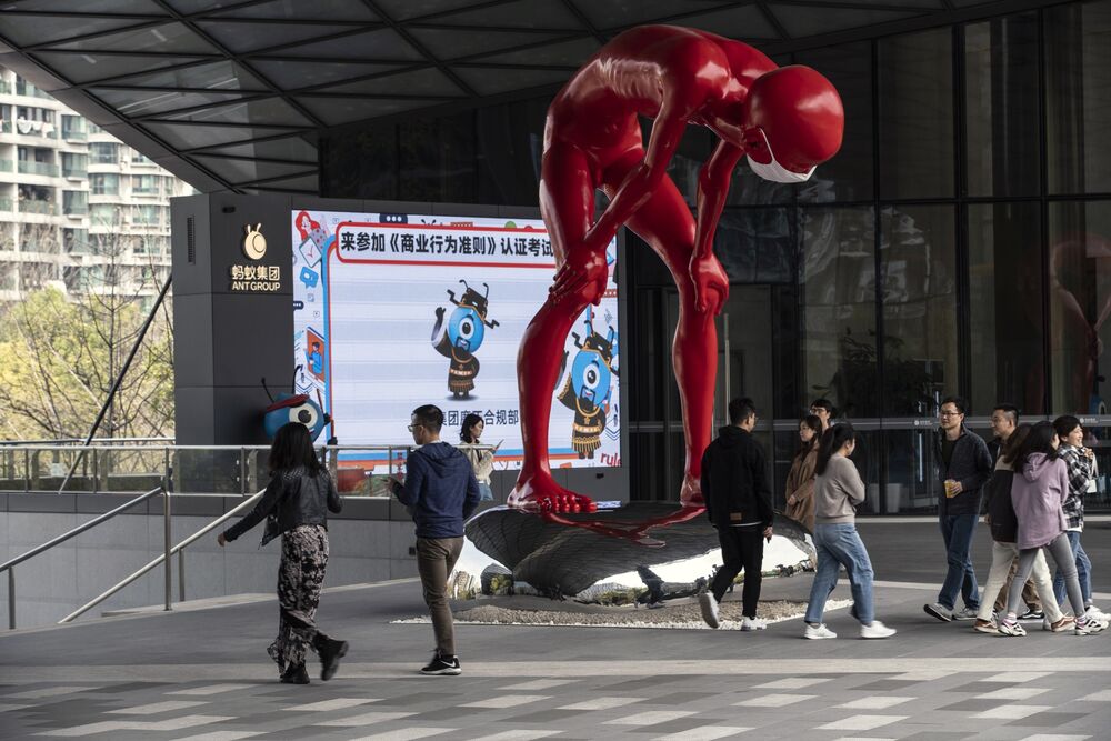 People walk past a sculpture by artist Chen Wenling at the Ant Group Co. headquarters in Hangzhou.