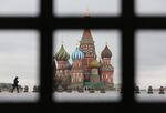 A pedestrian wearing a protective face mask browses a smartphone in Red Square near the Kremlin in Moscow.