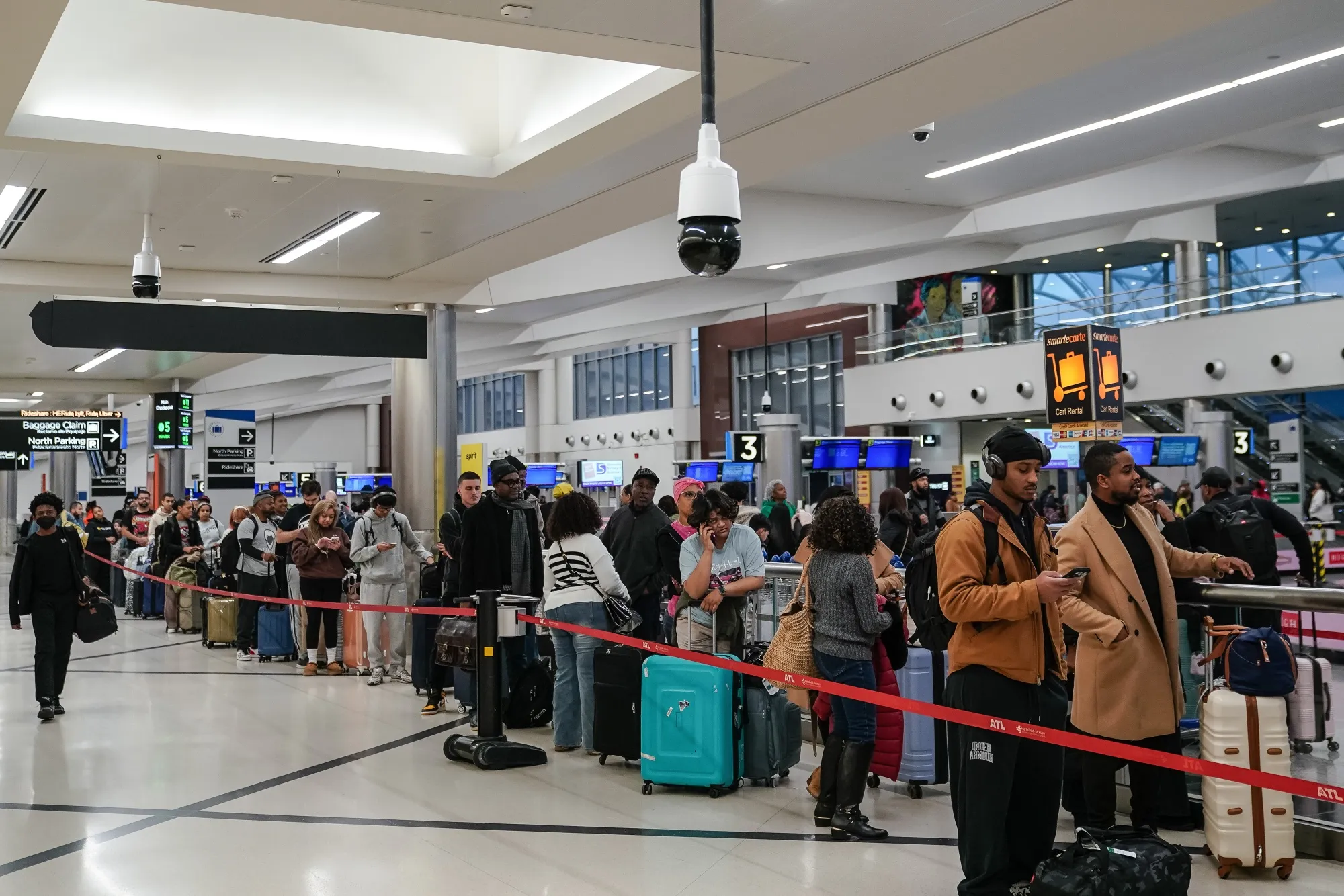 Travelers in a Frontier Airlines check-in line at Hartsfield-Jackson Atlanta International Airport in Atlanta on Dec. 23.