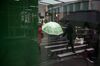 A pedestrian carries and umbrella while walking in New York, U.S., on Wednesday, Feb. 26, 2020. U.S. equities swung between gains and losses as investors digested fresh evidence of the widening coronavirus outbreak.