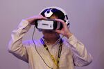 An attendee tries a video game on a Samsung Galaxy Gear Virtual-Reality (VR) headset.