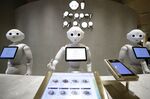 SoftBank Group Corp. Pepper humanoid robots stand behind a counter at the Pepper Parlor cafe in Tokyo, Japan