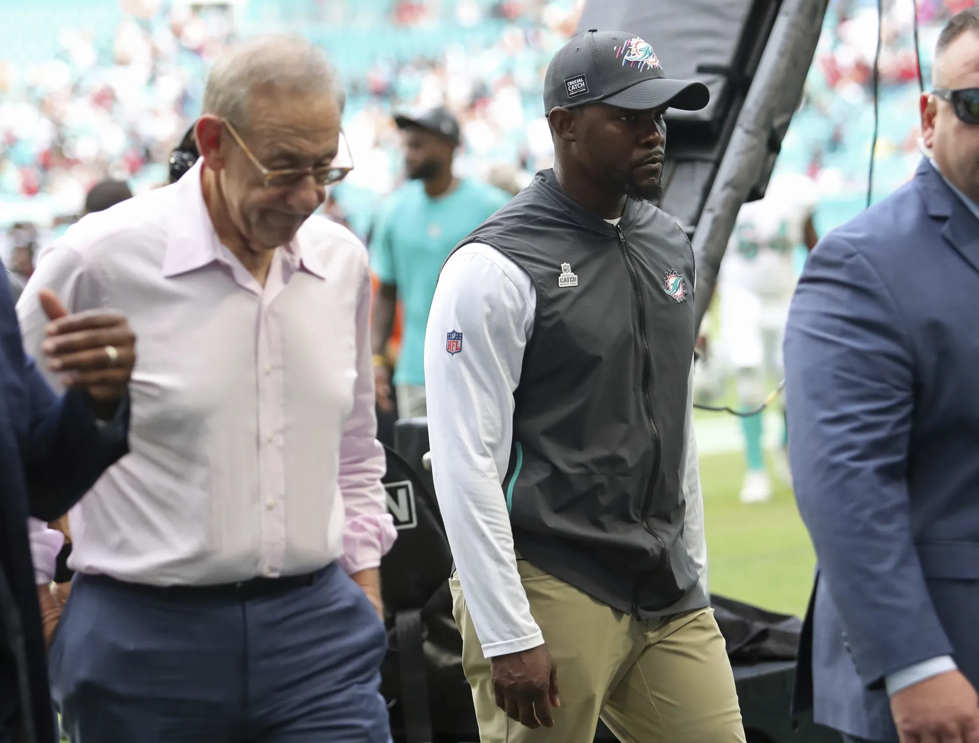 Miami Dolphins owner Stephen Ross, left, walks off the field next to coach Brian Flores after the team's loss to the Atlanta Falcons in an NFL football game Oct. 24, 2021, in Miami Gardens, Fla. Fired Dolphins coach Flores sued the NFL and three teams Tuesday, Feb. 1, over alleged racist hiring practices for coaches and general managers, saying the league remains “rife with racism” even as it publicly condemns it. According to the lawsuit, Ross told Flores he would pay him $100,000 for every loss during the coach’s first season because he wanted the club to “tank” so it could get the draft’s top pick. Messages left with the Dolphins seeking comment were not immediately returned. (John McCall/South Florida Sun-Sentinel via AP, File)
