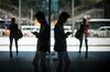 A man is reflected in a window while using a smart phone in Hong Kong, China.