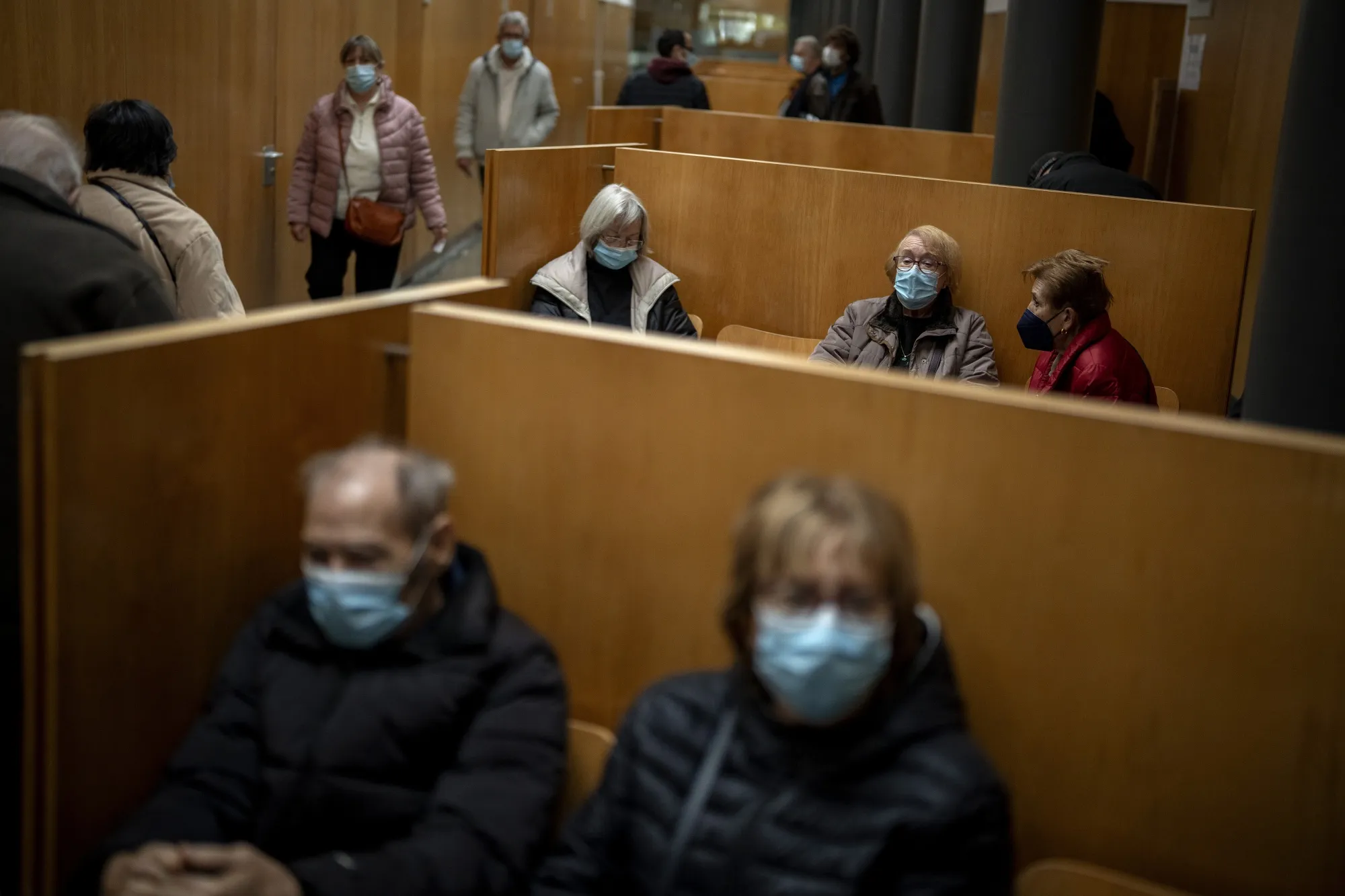 People wearing face masks as a precaution wait for a doctor appointment inside a hospital in Barcelona, Spain, Monday, Jan. 8, 2024. Regional and national health chiefs are meeting Monday to decide whether to extend mandatory maskwearing to all health facilities following an epidemic outbreak of flu and other respiratory viruses that are putting a strain on the system.