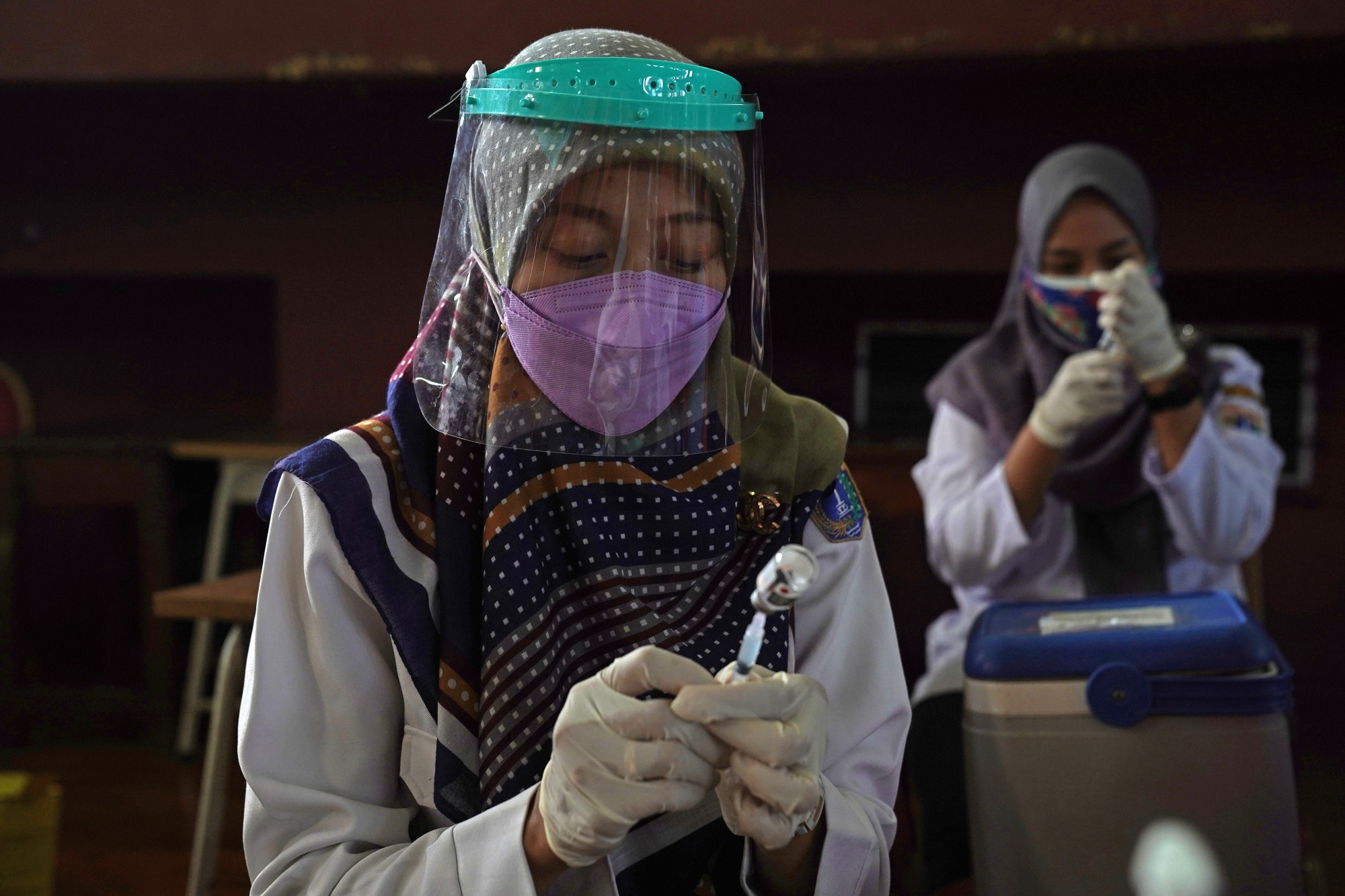Health workers at a vaccination center in Jakarta, Indonesia.