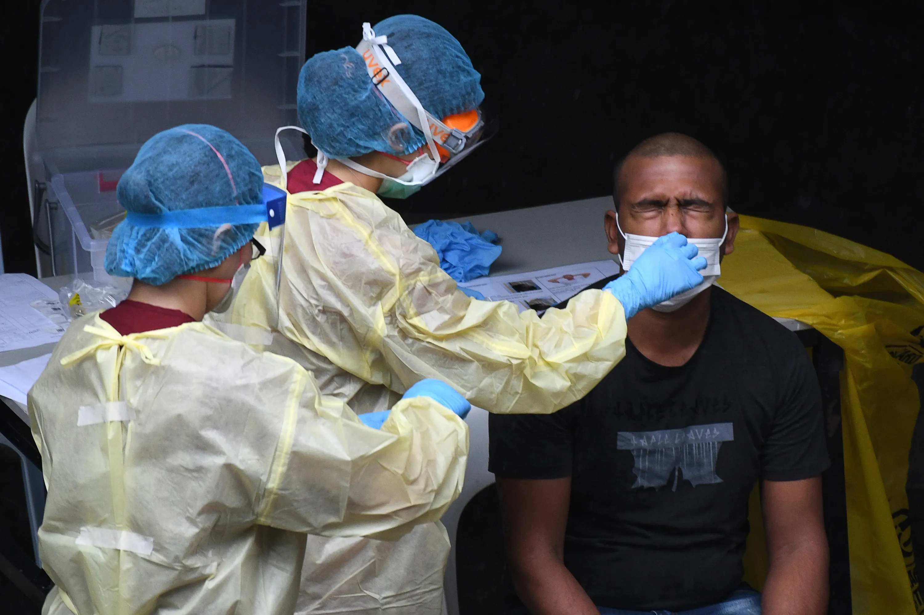 A healthcare worker&nbsp;collects a nasal swab sample from a migrant worker for testing for Covid-19&nbsp;at a foreign workers' domitory in Singapore on April 27.
