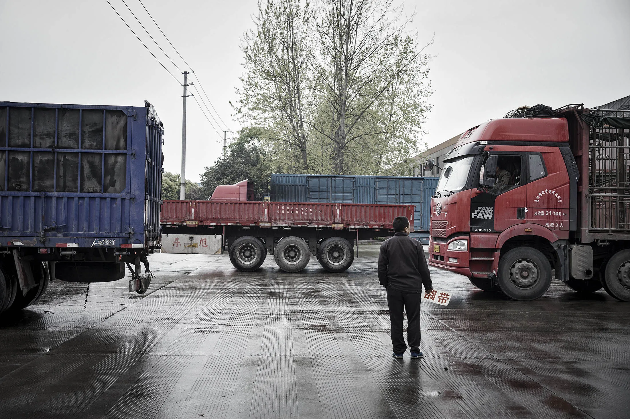 A man offering his services as a road guide stands outside of a logistics park in Chengdu, China, on Tuesday, April 11, 2017. Truck Alliance Inc., known as Huochebang or truck gang in Chinese, is trying to bring the smartphone age to a trillion dollar industry that carries 80 percent of the country's cargo, yet has haulers standing emptynearly half the time.
