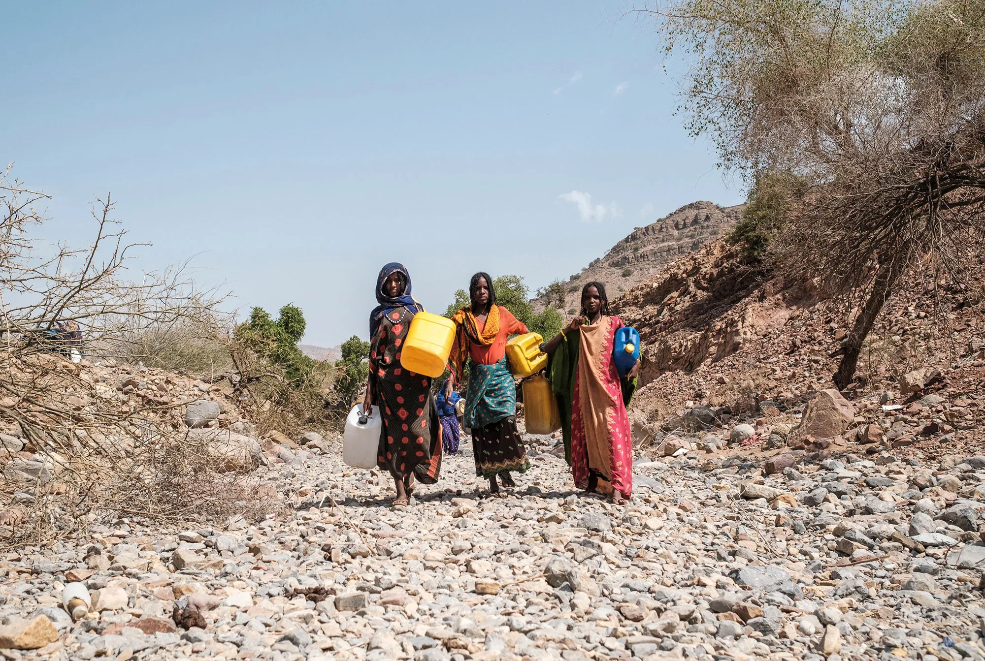 Internally displaced people carry jugs in a&nbsp;makeshift camp where they are sheltered in the village of Erebti, Ethiopia, on June 9.&nbsp;