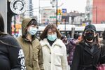 Pedestrians wearing face masks walks along a street in the Flushing neighborhood in the Queens Borough of New York, U.S.
