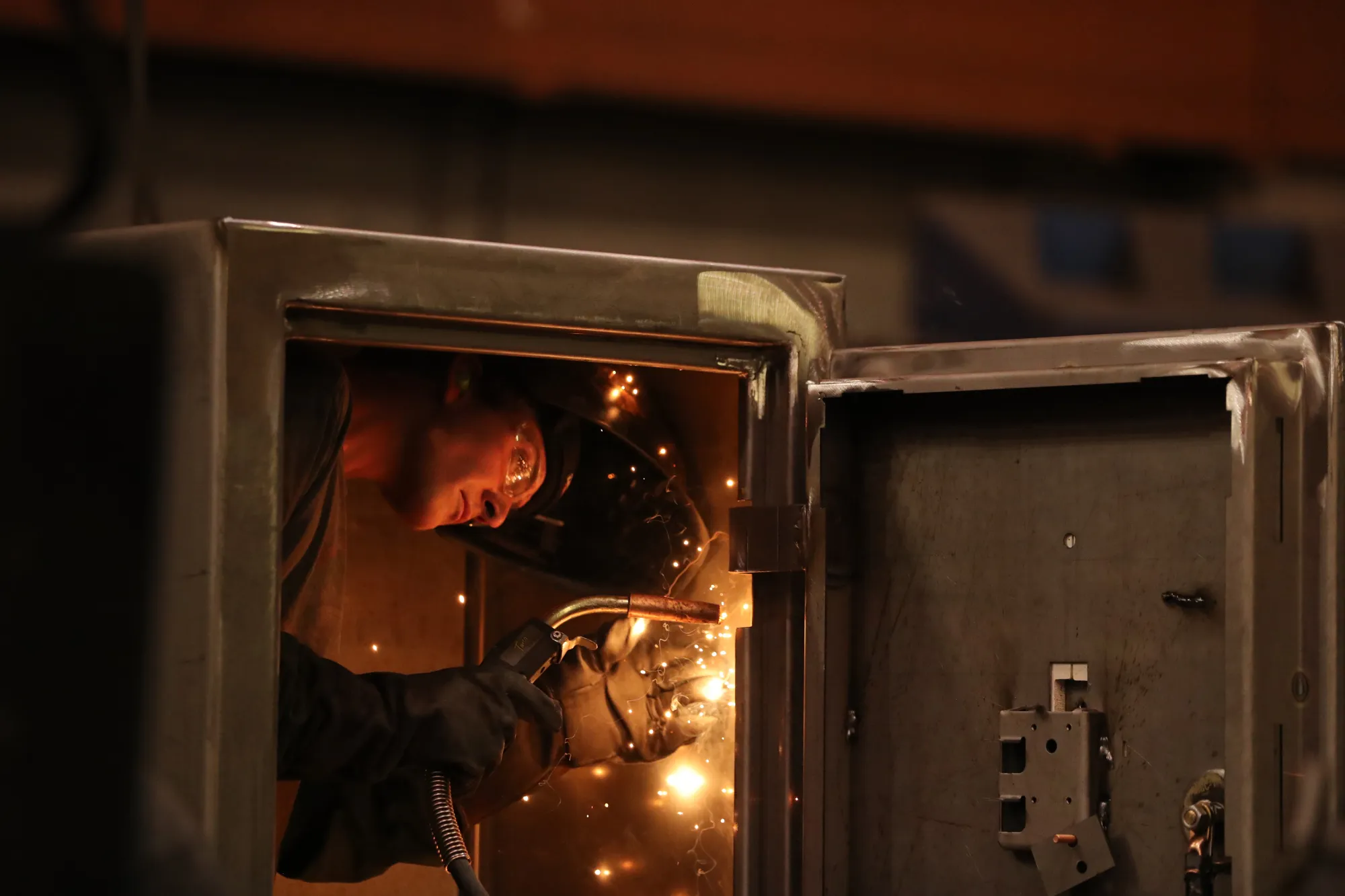 A worker welds a door inside a safe at a manufacturing facility in Payson, Utah.