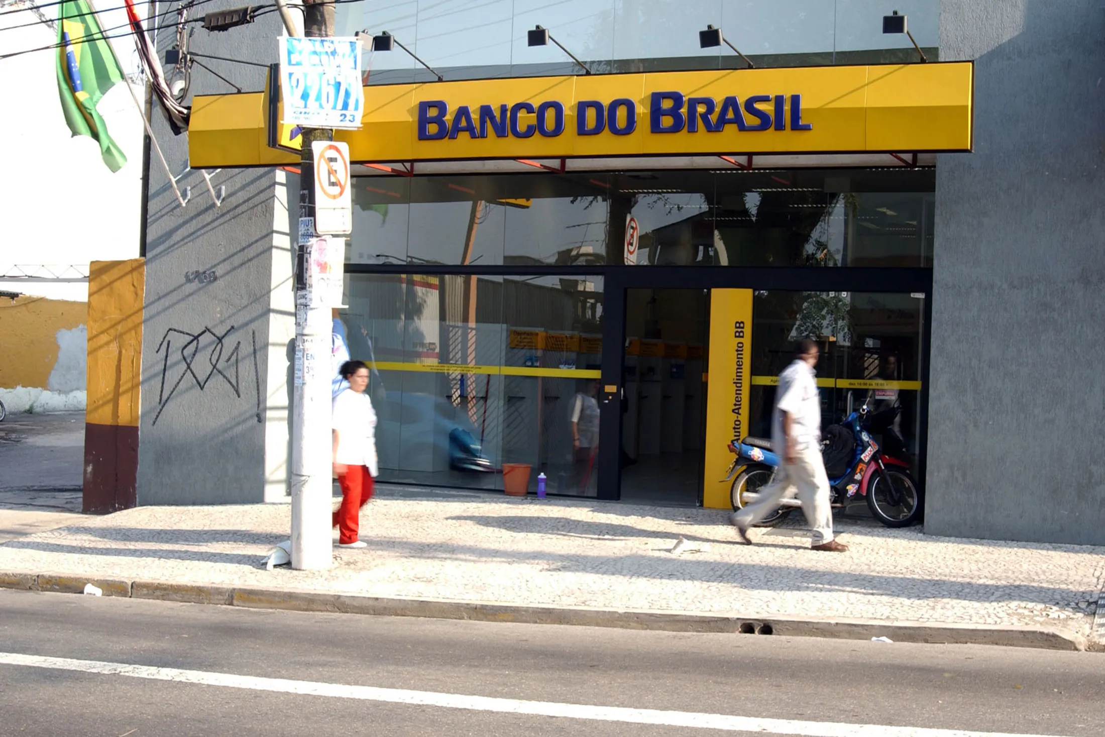 Pedestrians walk past a Banco do Brasil branch bank in Sao Paulo, Brazil, on Wednesday, October 2, 2002.