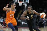 Las Vegas Aces guard Chelsea Gray (12) drives against Connecticut Sun forward Alyssa Thomas (25) during the first half in Game 2 of a WNBA basketball final playoff series Tuesday, Sept. 13, 2022, in Las Vegas. (AP Photo/John Locher)
