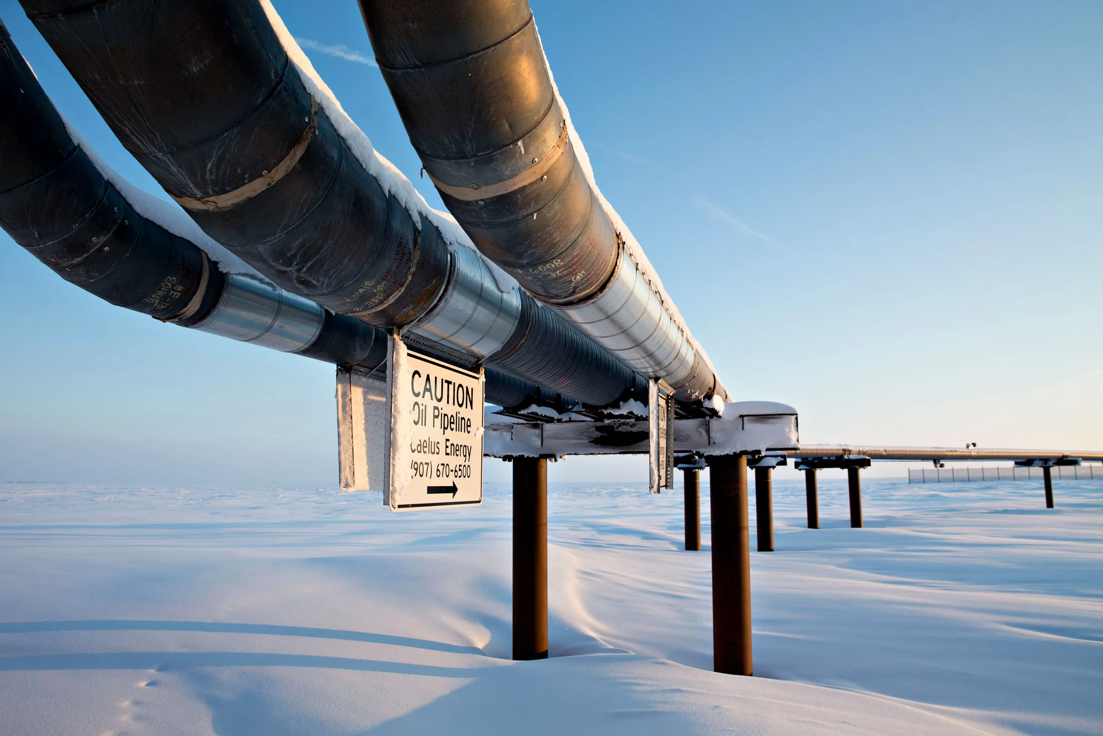 An oil pipeline runs from an on-shore tie-in facility, the production and metering facility for the Caelus Energy Oooguruk Development Project.

