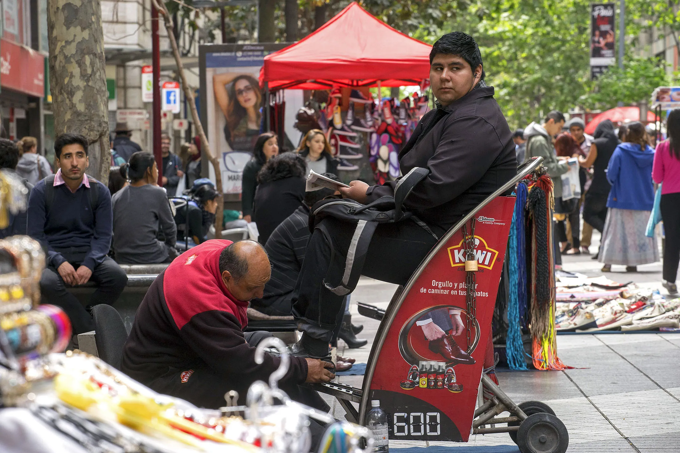 A man sits for a shoe shine in Santiago, Chile.
