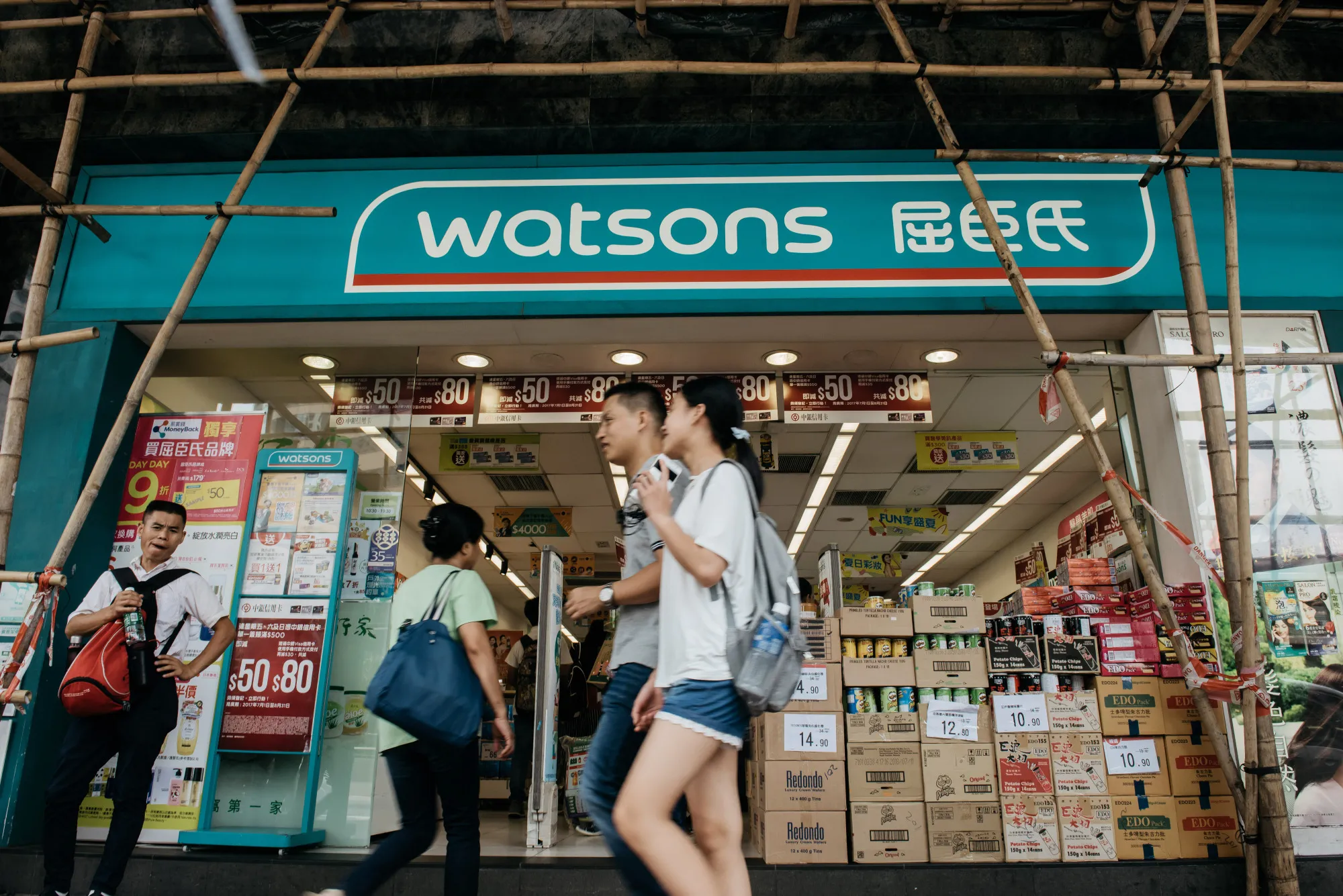 Pedestrians walk past a Watsons store in Hong Kong, China.