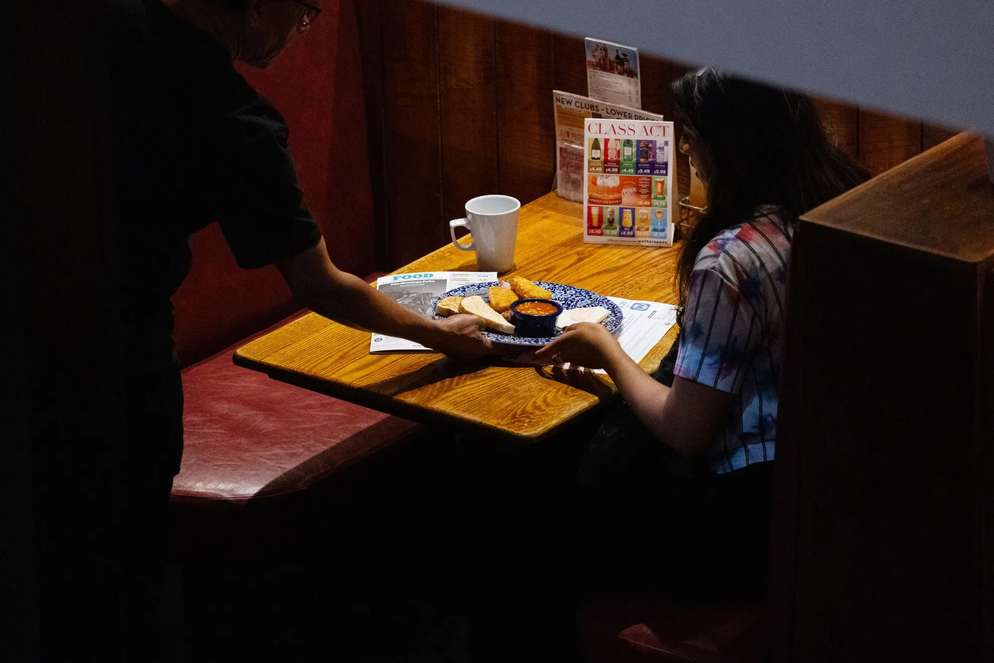 An employee serves a breakfast order to a customer at the Montagu Pyke pub, operated by JD Wetherspoon Plc, in central London, UK, on Wednesday, Sept. 24, 2025. JD Wetherspoon are due to release their preliminary results on Oct. 3.