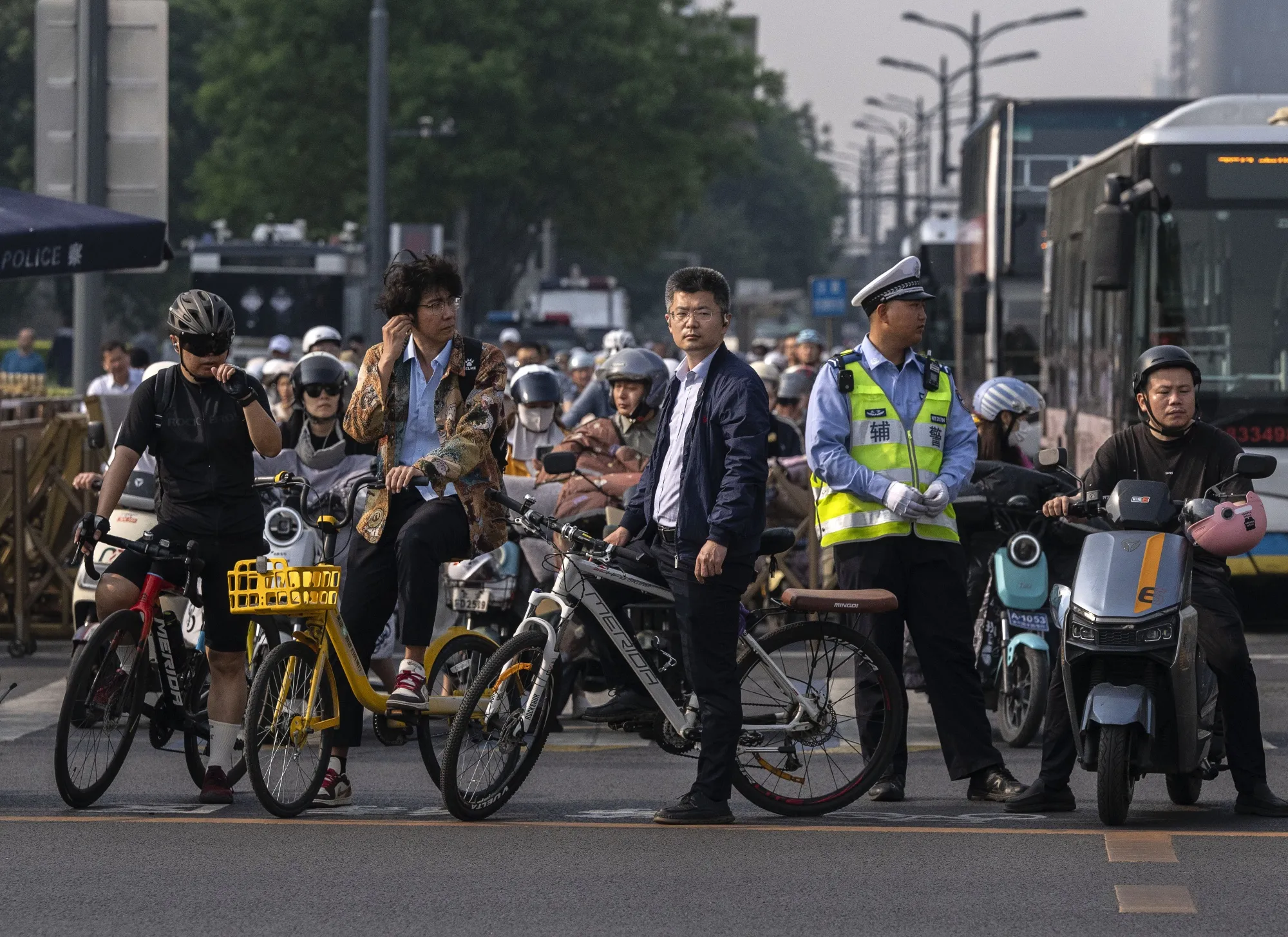 Commuters wait at a traffic light next to a police officer near Tiananmen Square.