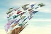 International currency flying as money paper airplanes