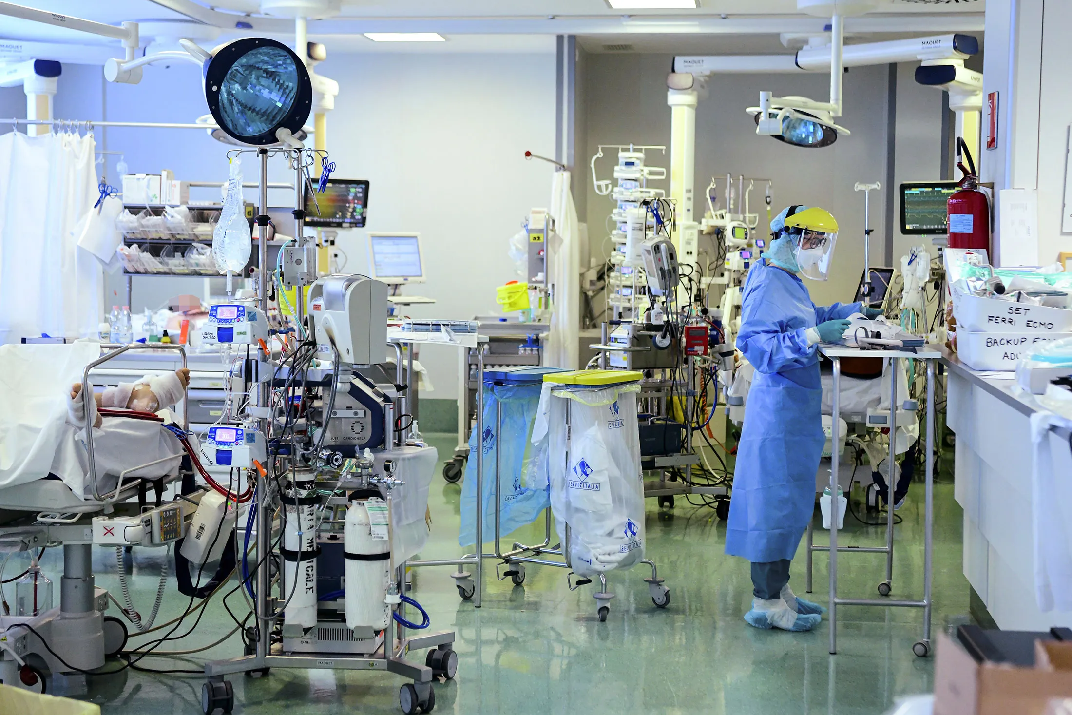 A healthcare worker wearing personal protective equipment stands by a patient in the Covid-19 division at the ASST Papa Giovanni XXIII hospital in Bergamo, on April 3.