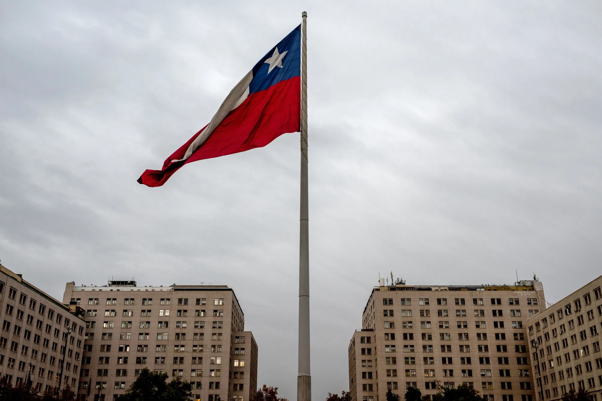 A Chilean national flag flies at Plaza de la Ciudadania in Santiago, Chile, on Monday, May 20, 2024. Chile's economy recorded the fastest quarterly growth since 2021, when government stimulus fueled domestic demand during the pandemic, as both mining output and consumption increased while slowing inflation and falling interest rates provided much-needed relief.