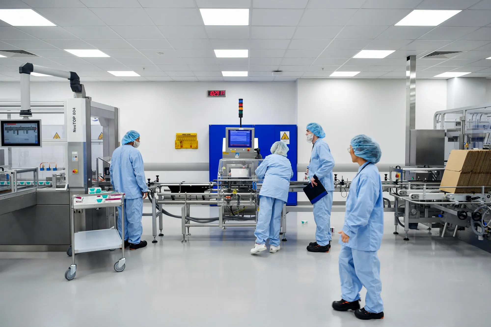 Operators work on the cartoner and casepacker machine at AstraZeneca Plc's new Biologics factory in Sodertalje, Sweden.