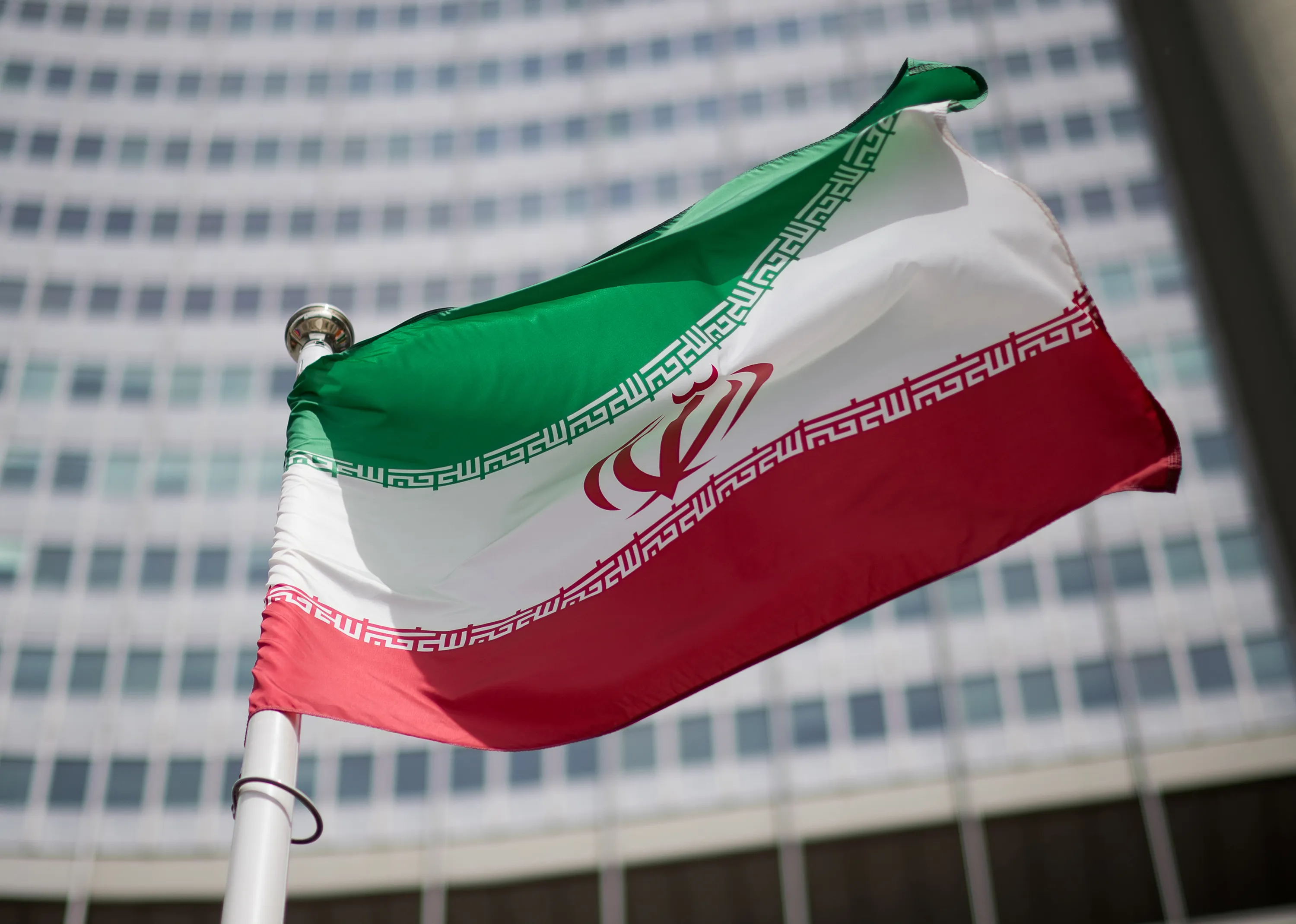 The flag of Iran&nbsp;in front of the building of the International Atomic Energy Agency (IAEA) Headquarters&nbsp;in Vienna, Austria.