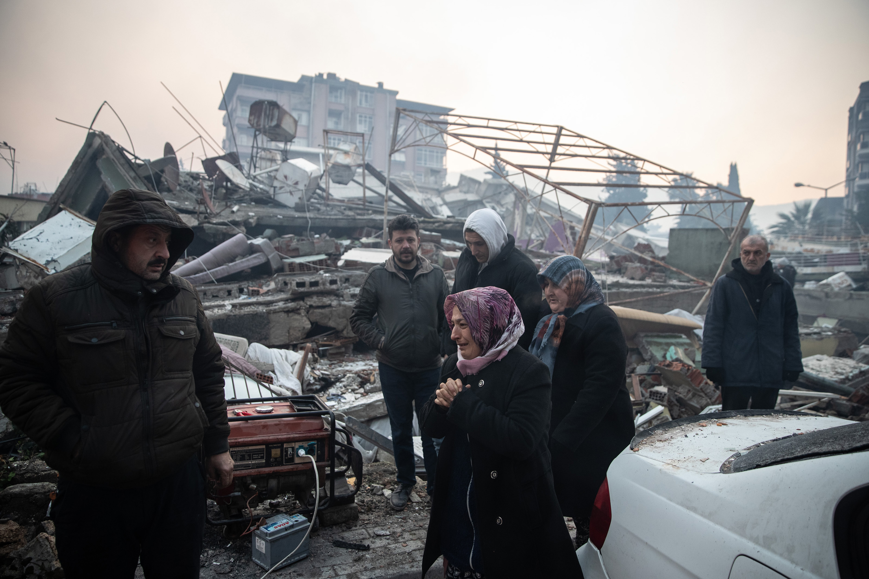 People wait for news of their loved ones, believed to be trapped under a collapsed building&nbsp;in Hatay, Turkey, on Feb. 7.&nbsp;Erdogan plans to visit the worst-hit cities of Kahramanmaras and Hatay Wednesday.