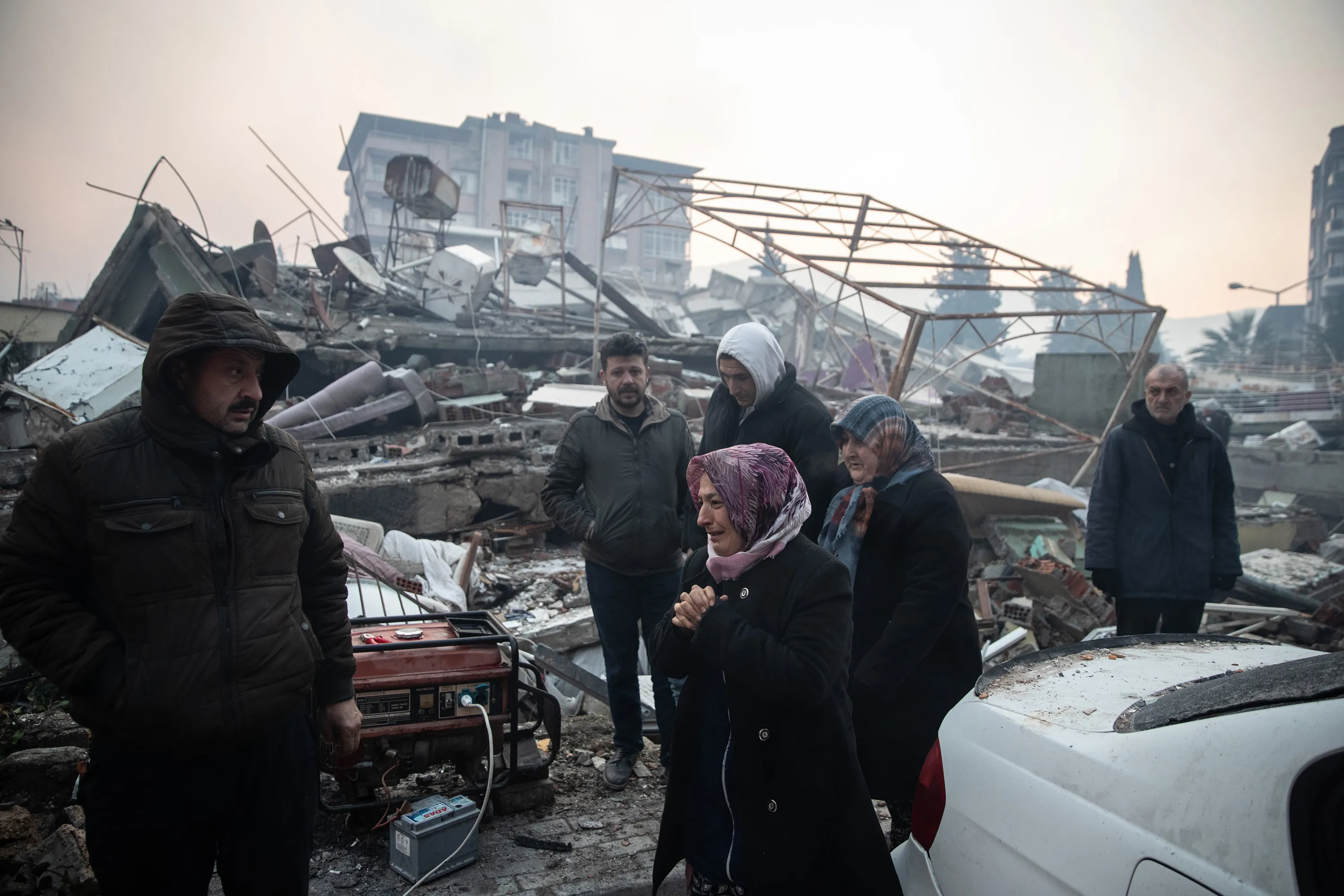 People wait for news of their loved ones, believed to be trapped under a collapsed building&nbsp;in Hatay, Turkey, on Feb. 7.&nbsp;Erdogan plans to visit the worst-hit cities of Kahramanmaras and Hatay Wednesday.