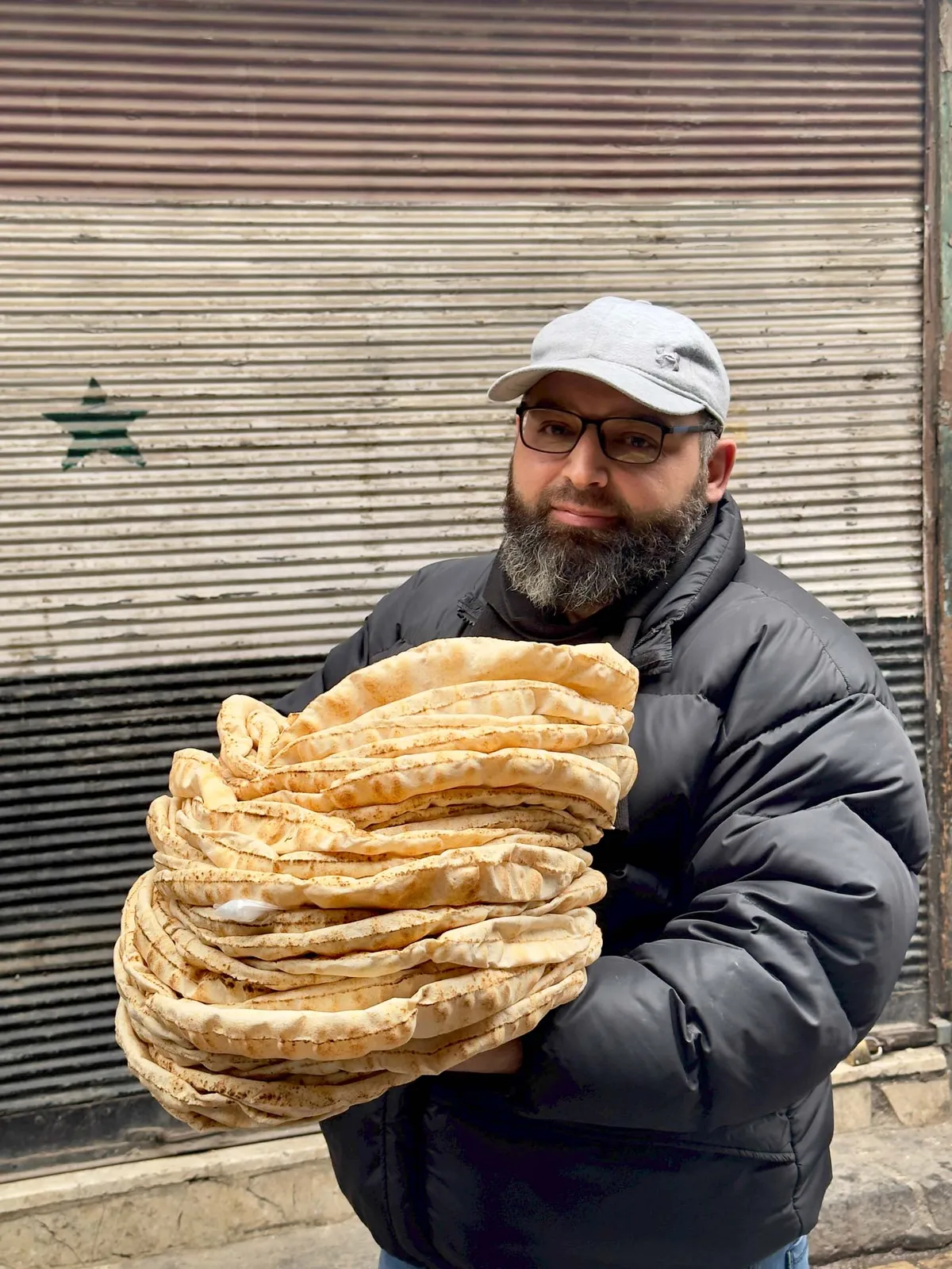 مشتری در حال حمل نان از نانوایی در خیابان مستقیم. عکاس: انیسا حلو/بلومبرگ