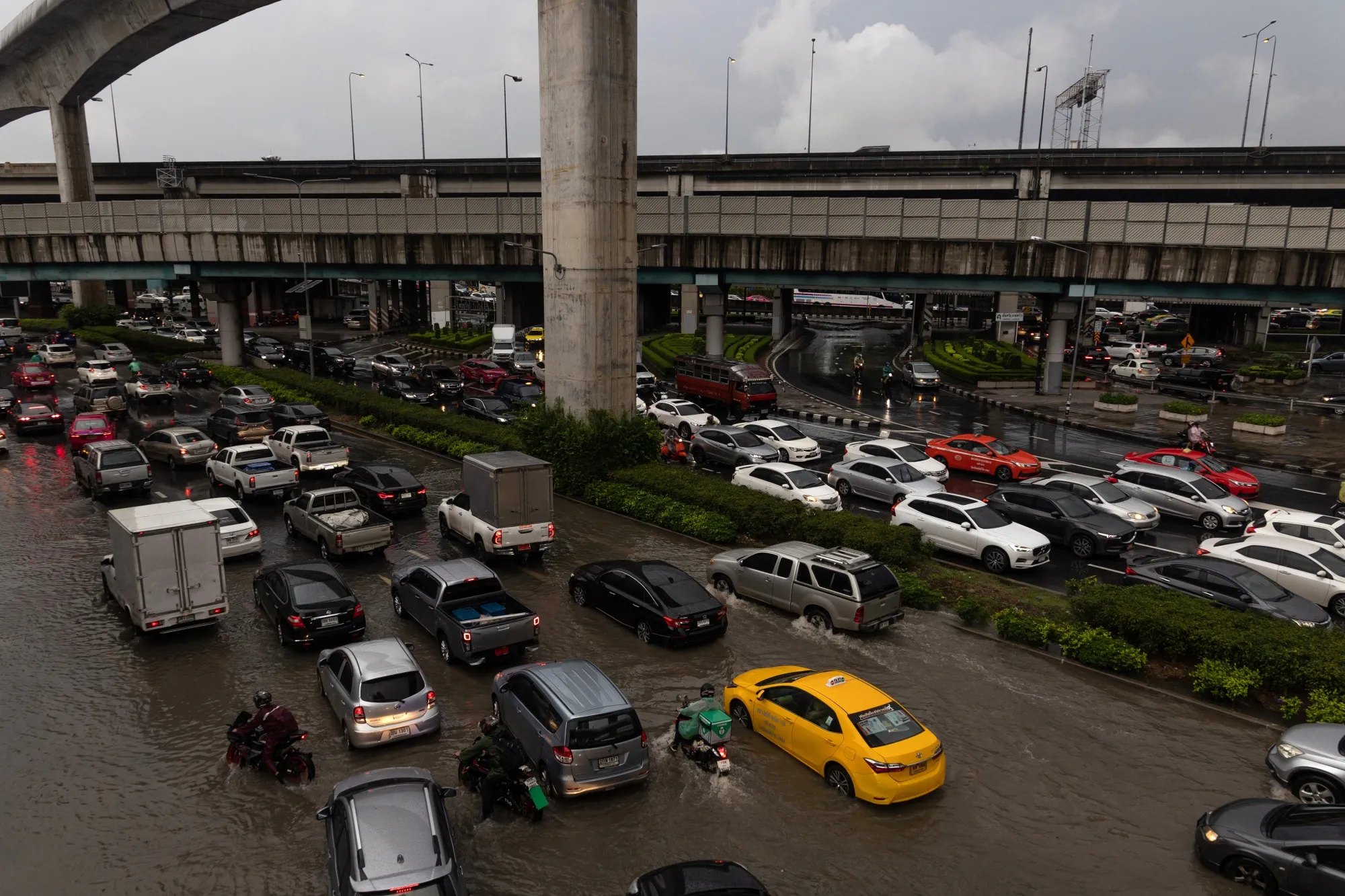 Vehicles wade through flooded roads after a torrential downpour in Bangkok on Oct. 3.
