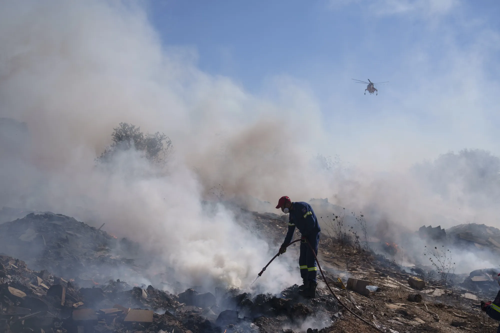A firefighter tries to extinguish a blaze south east of Athens, on June 19.