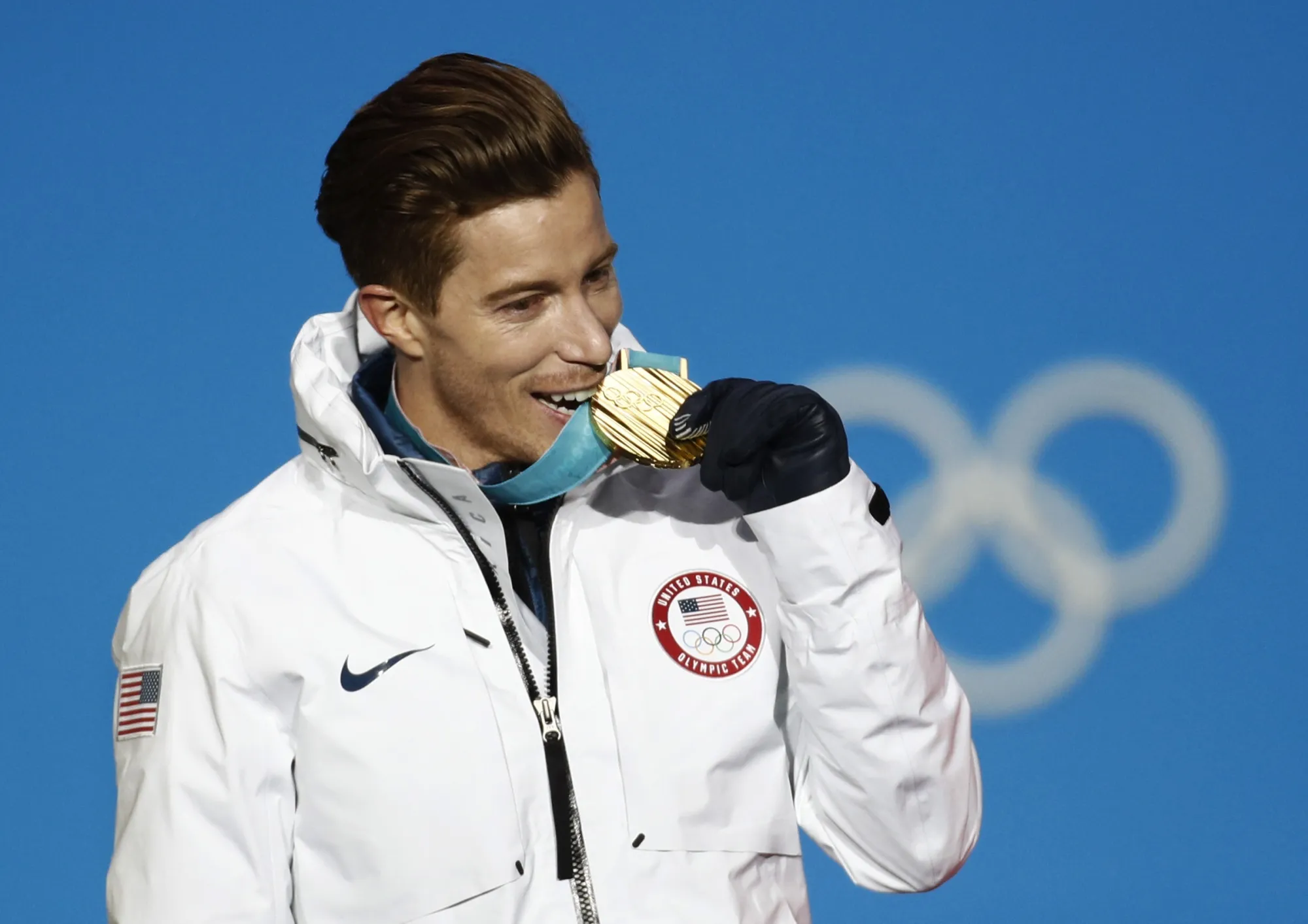 Men's halfpipe gold medalist Shaun White, of the United States, bites his medal during the medals ceremony at the 2018 Winter Olympics in Pyeongchang, South Korea, Wednesday, Feb. 14, 2018. As Shaun White embarked this month on the quest to make his fifth Olympics, the world’s most famous halfpipe rider finds living a life full of calculated risks is still part of his DNA. It's a mindset that is less taken for granted these days in all-or-nothing sports like his than it was a mere 12 months ago.  (AP Photo/Patrick Semansky, File)