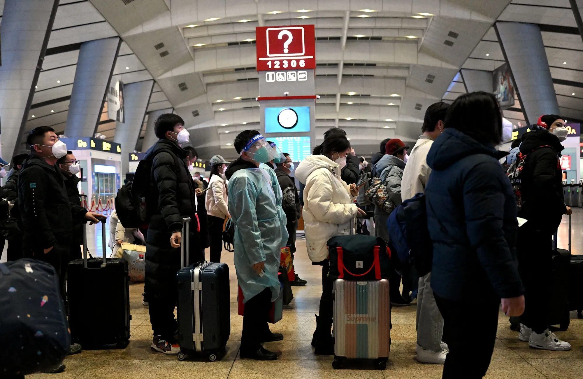 Passengers stand in line at a train station in Beijing on Jan. 5.