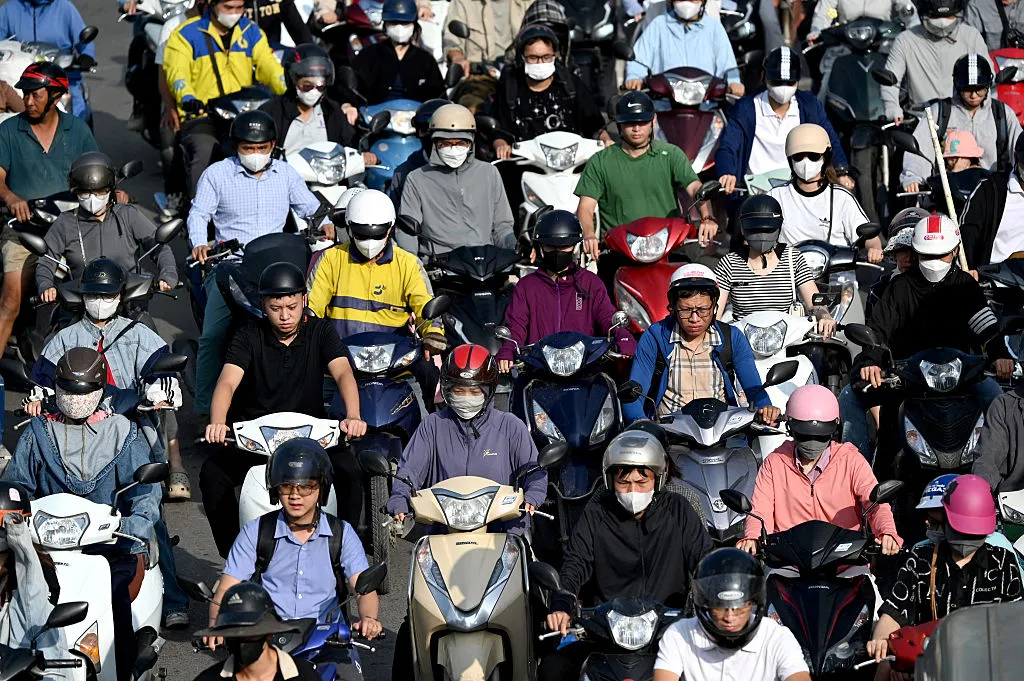 Commuters driving motorbikes on a street in Hanoi.&nbsp;