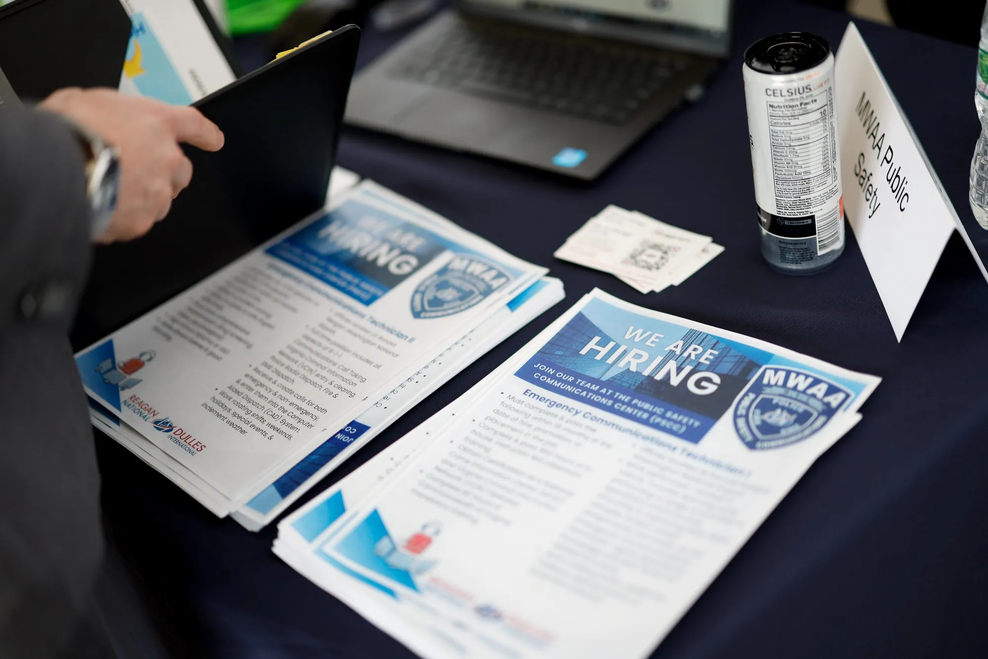 "We're Hiring" pamphlets on a table during a job fair hosted by the Metropolitan Washington Airports Authority.