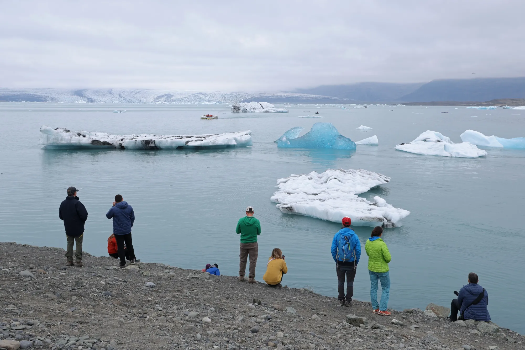 Tourists look at icebergs at Jokulsarlon lake near Hof, Iceland.