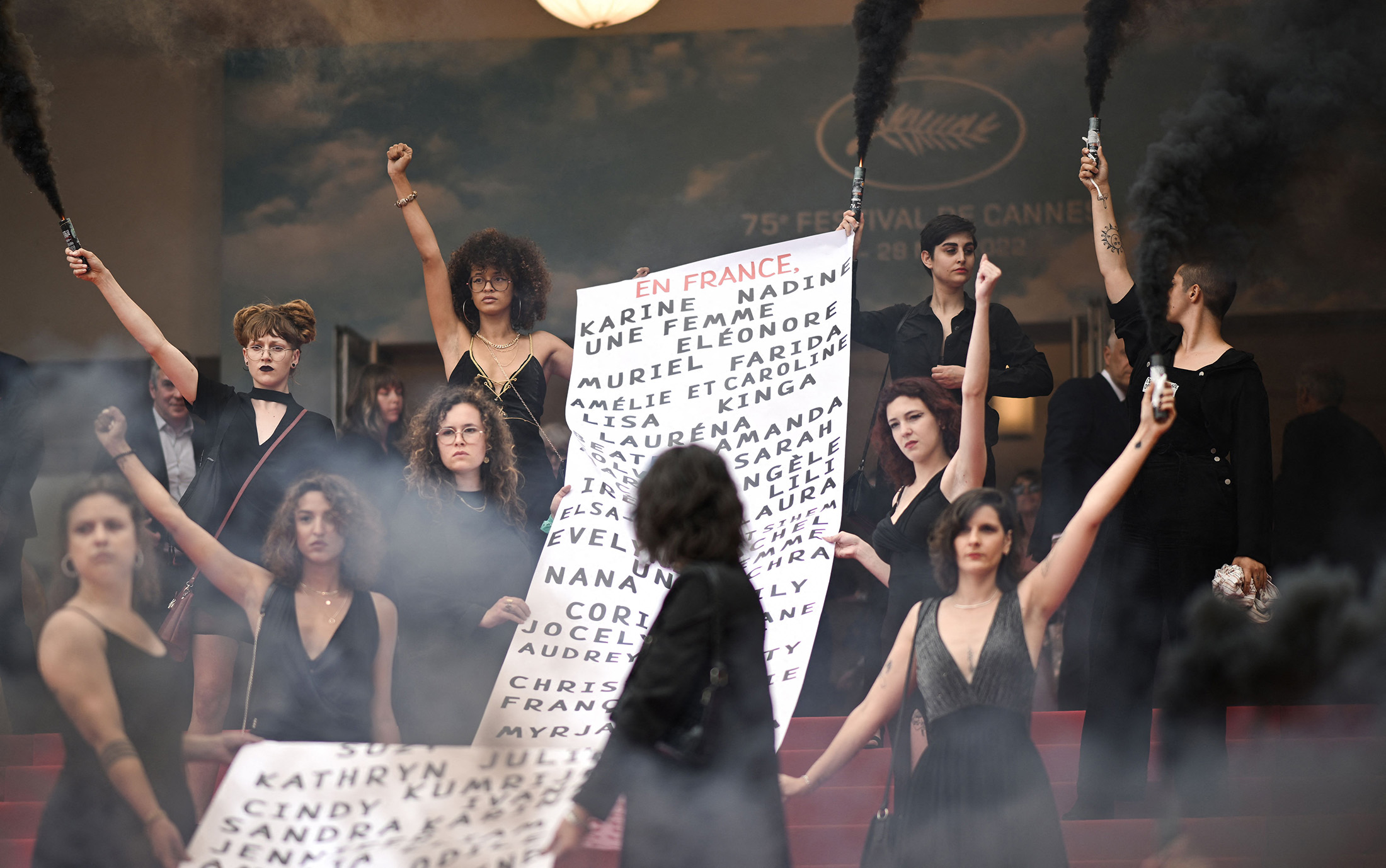Protesters with the feminist movement &quot;Les Colleuses&quot; hold a banner, on the red carpet of the&nbsp;Cannes Film Festival on May 22, 2022.&nbsp;