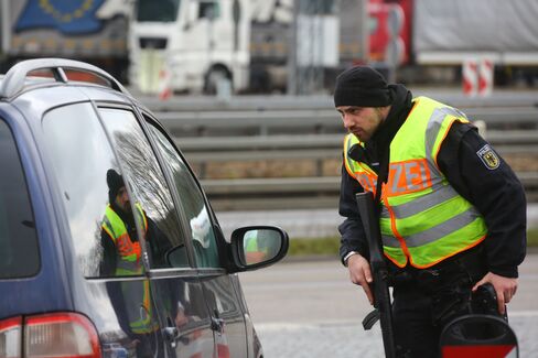 A police officer checks a car at the border between Germany and Belgium