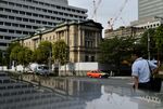 Pedestrians walk past the Bank of Japan (BOJ) headquarters in Tokyo, Japan, on Wednesday, Sept. 13, 2017. The BOJ's next monetary policy meeting is scheduled for Sept. 21. The central bank pushed back in July the projected timing for reaching its 2 percent inflation target for the sixth time as economic growth failed to drive price gains.