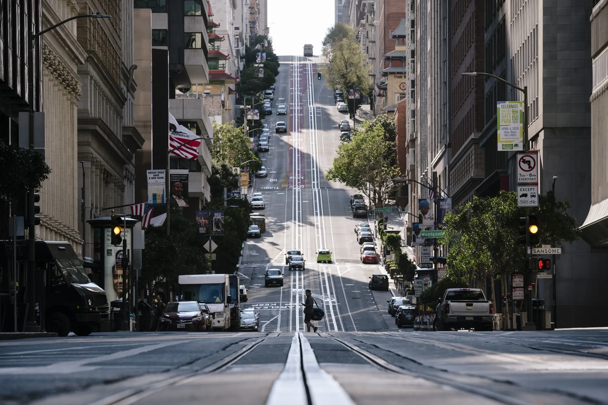 A pedestrian crosses the near empty California Street in San Francisco.