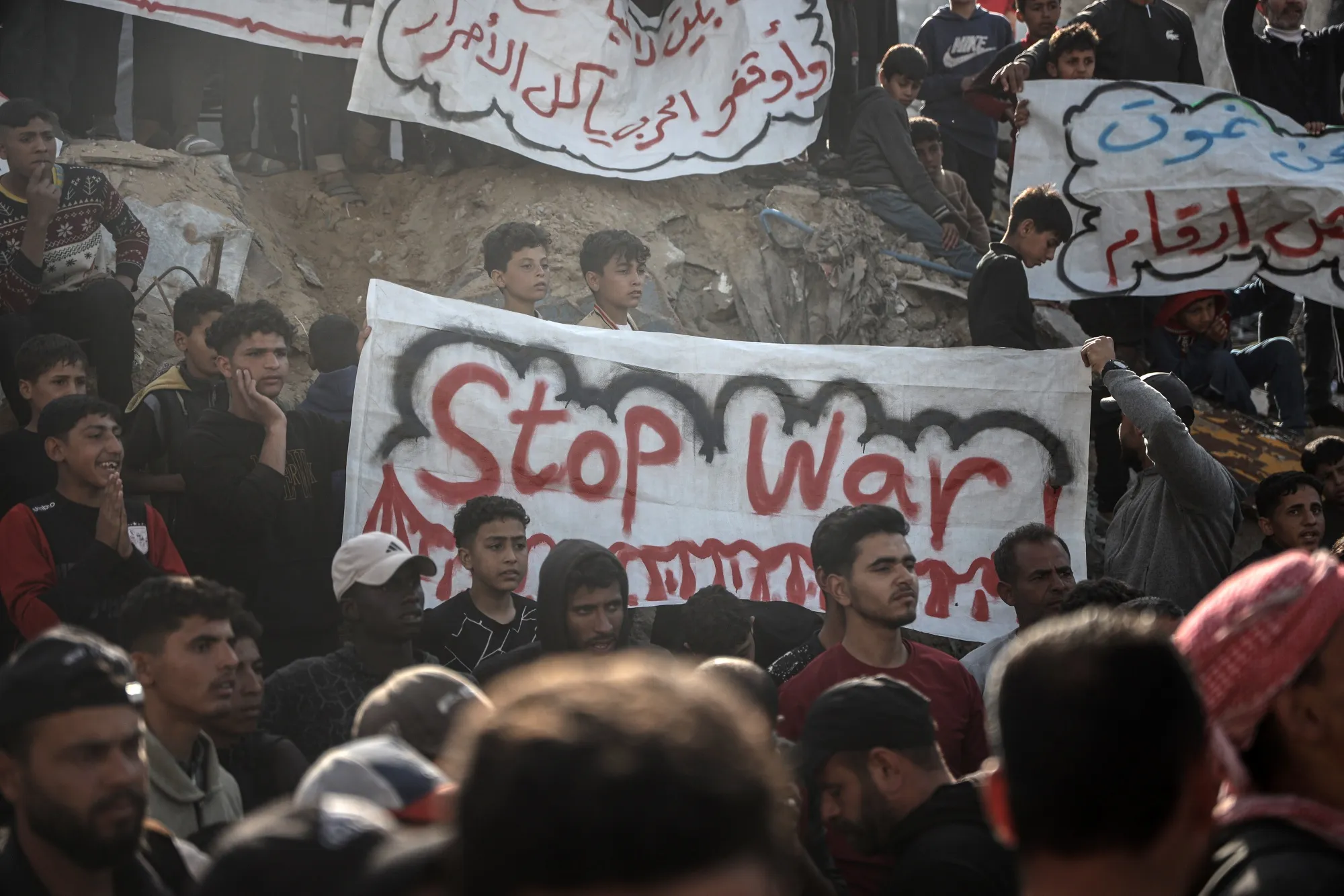 Protesters with a "Stop War" sign during a demonstration against the Hamas militant group in Beit Lahiya, northern Gaza, on March 26.