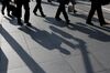 Morning commuters cast shadows on a sidewalk in Tokyo, Japan, on Monday, May 14, 2018. Japan is scheduled to release its first-quarter gross domestic product (GDP) figures on May 16.