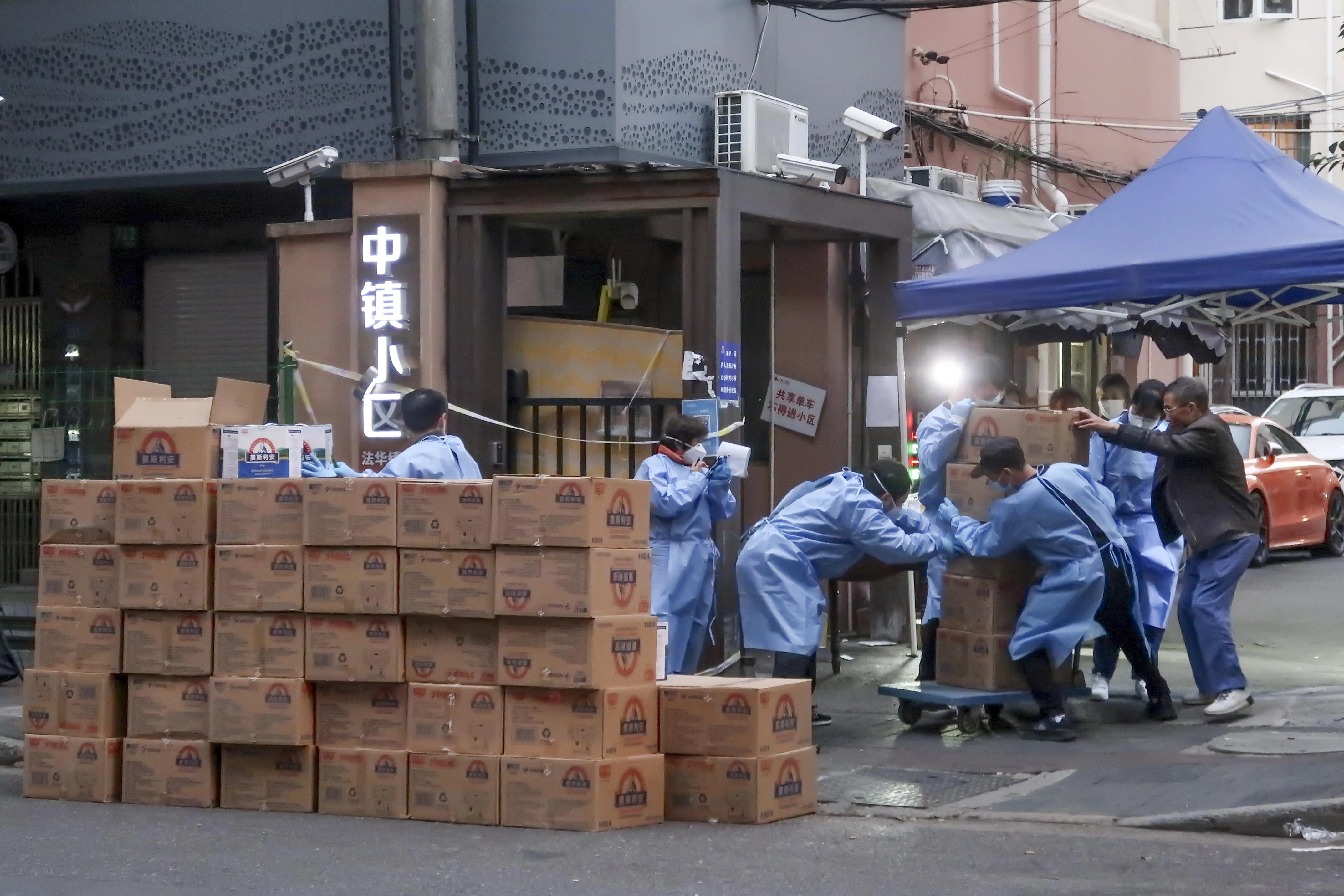 Workers deliver supplies to residents at an area placed under lockdown due to Covid in Shanghai on Oct. 11.