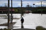 A member of Japan's Fire and Disaster Management Agency wades through floodwaters in the aftermath of Typhoon Hagibis in Kurihara city, Miyagi Prefecture.