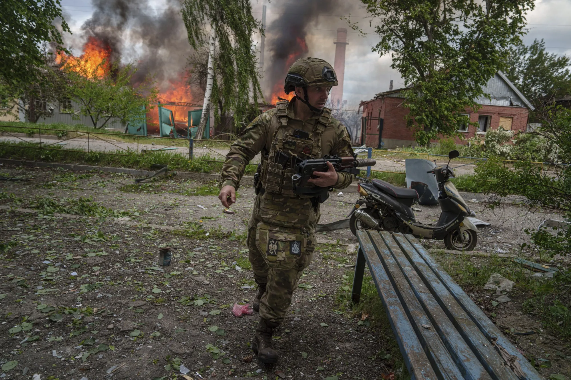 A police officer runs in front of&nbsp;burning house destroyed by a Russian airstrikes, in Vovchansk, Kharkiv Oblast, on&nbsp;May 11.&nbsp;