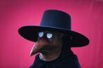A man dresses as a plague doctor.